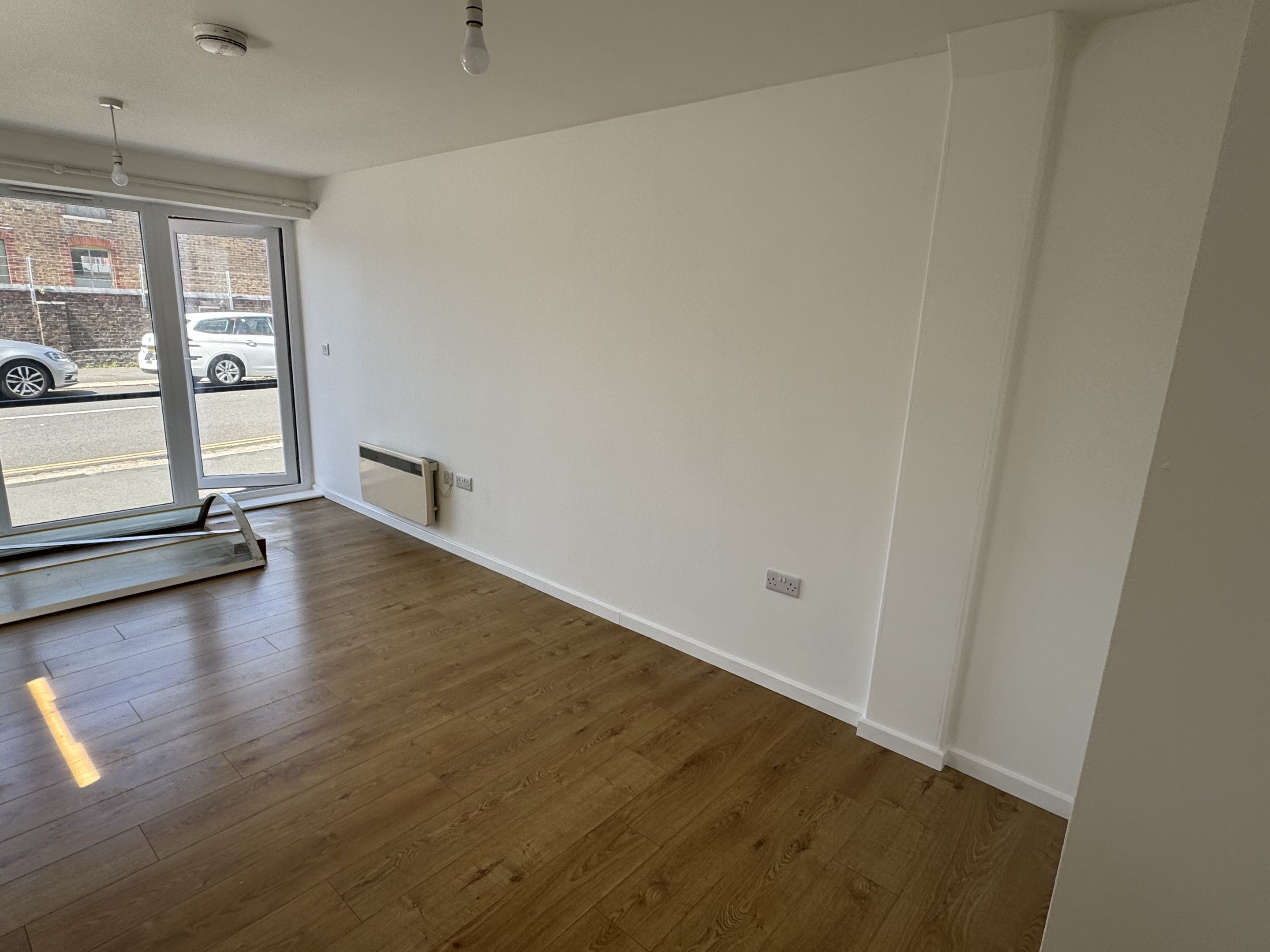 Redecorated apartment living room with a clean white finish and large window