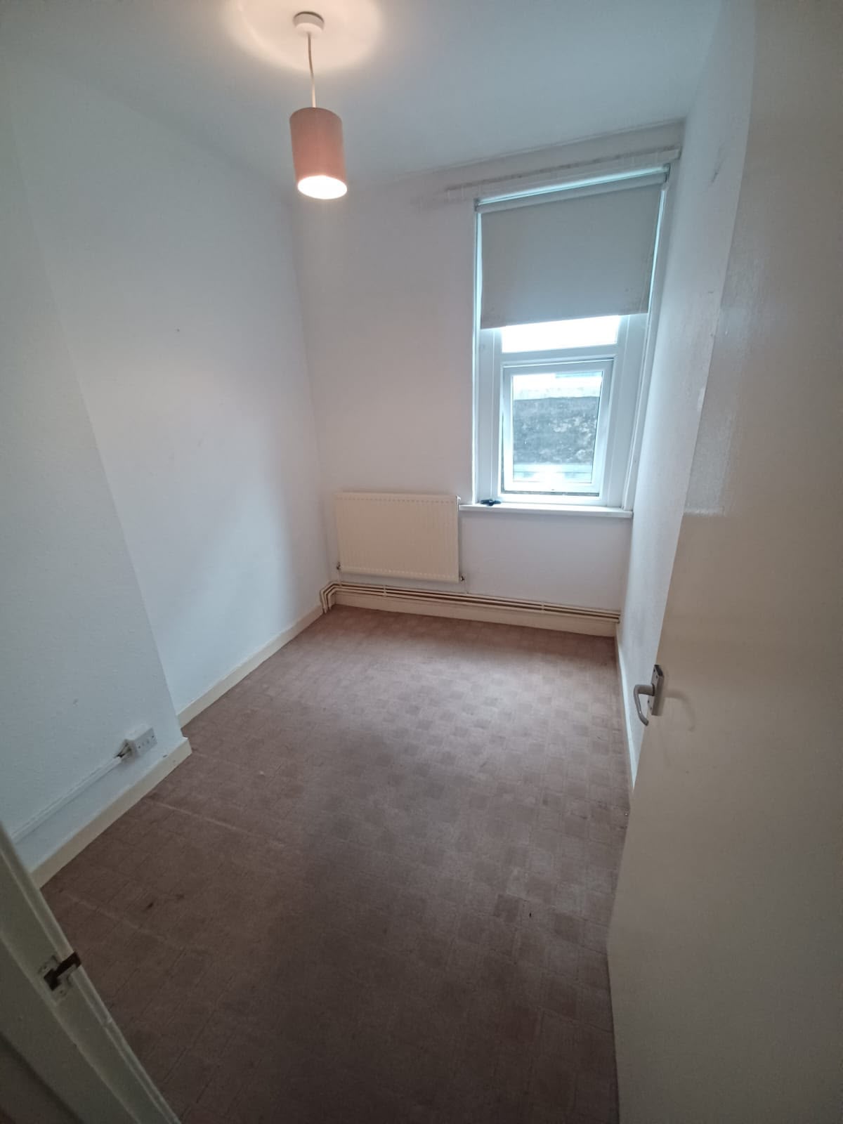 Small bedroom with old worn carpet before renovation